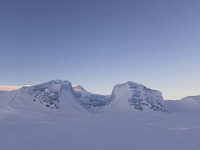 a snow covered iceberg in a snow covered frozen lake at dawn