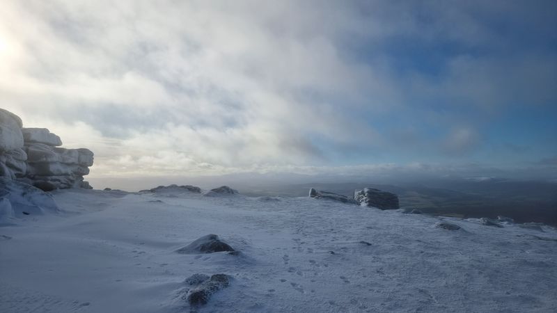 snow covered summit, with a hazy cloudy view