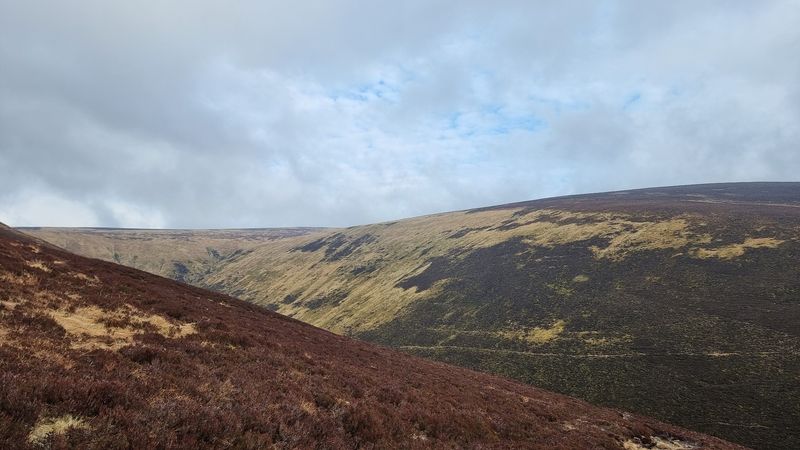 A brown slope in the foreground, with a steep, flat-topped hill beyond. headwaters of Allt Scheicheachan